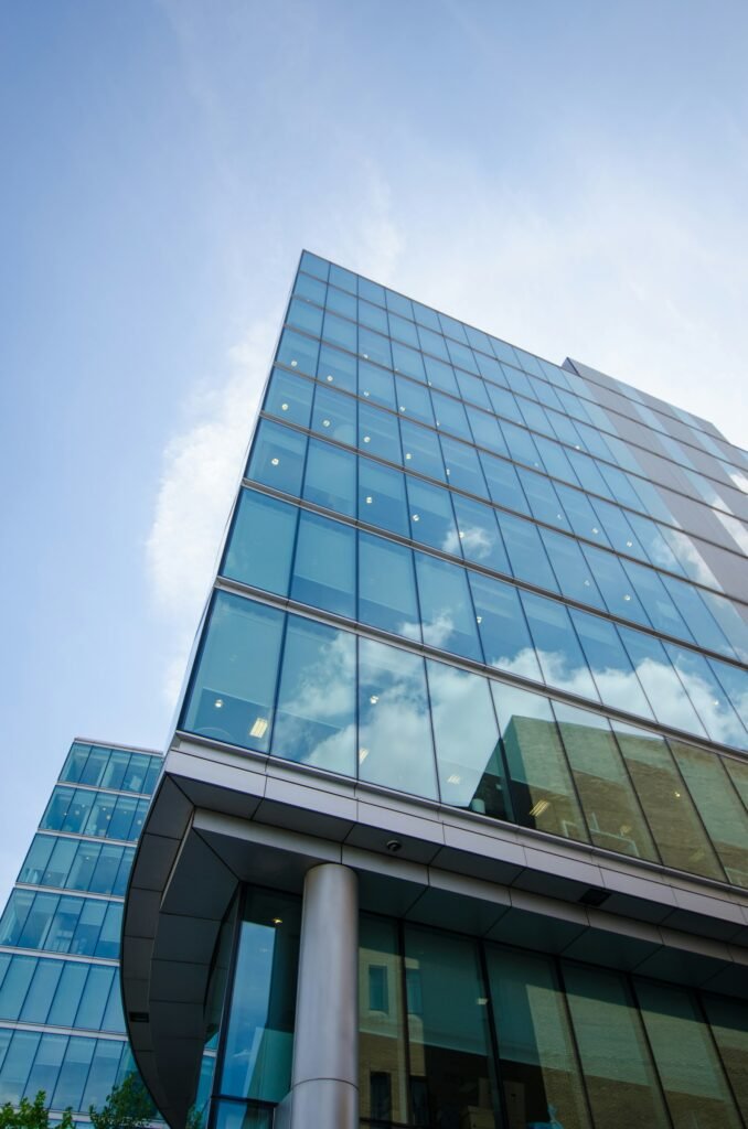 Façade de verre d’un immeuble de bureaux reflétant les nuages
